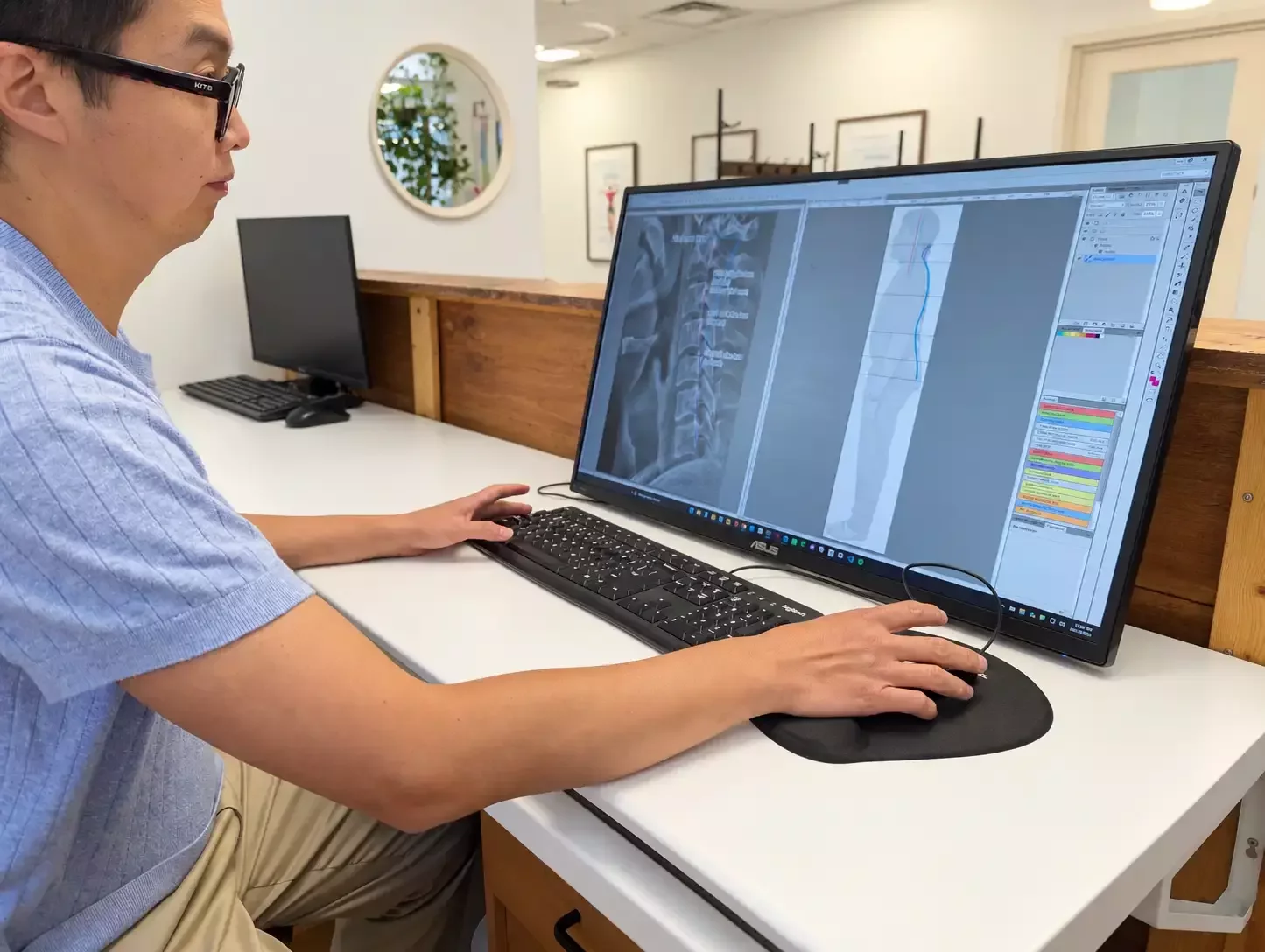 Dr. Leo Quan assessing a patient’s posture photograph and cervical X-ray with alignment measurements on a computer screen at Source Chiropractic.