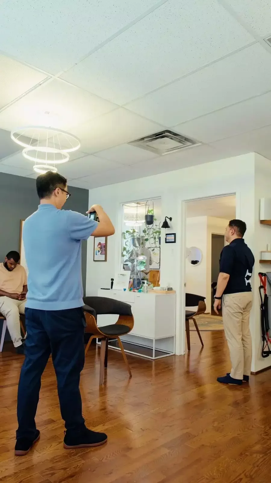 Dr. Leo Quan conducting a posture examination with a patient standing at Source Chiropractic in downtown Toronto.