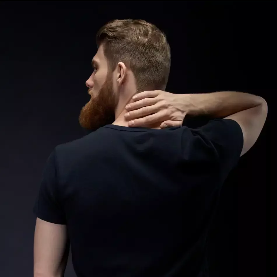 Man holding the back of his neck while turning his head to the side.